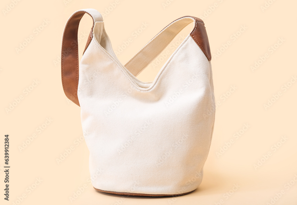 Stylish white handbag on beige background