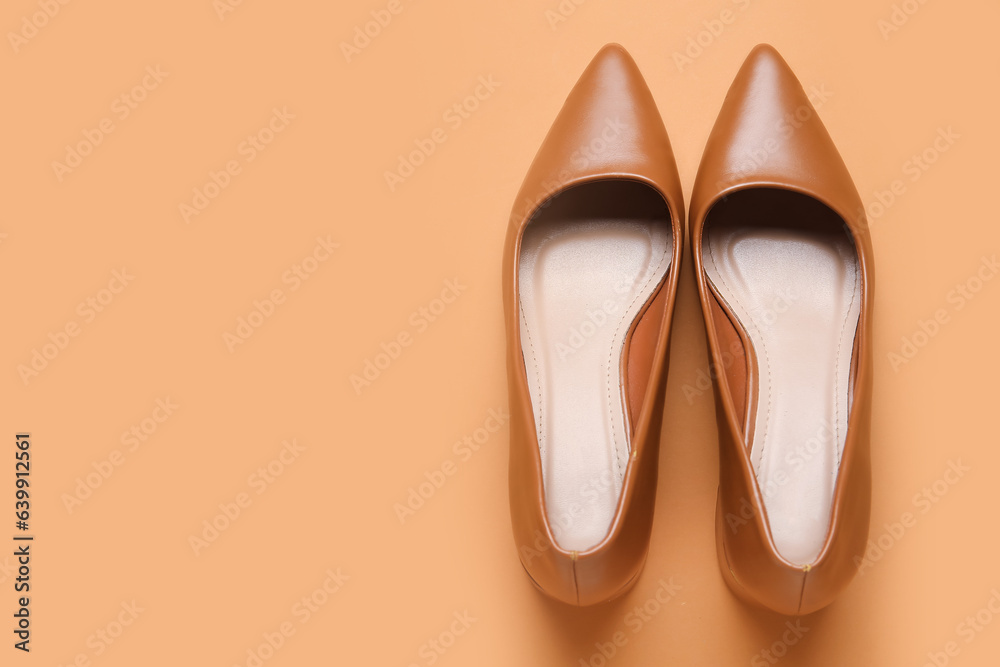 Stylish brown high heels on color background