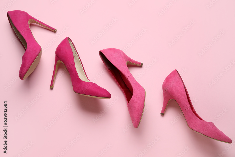 Stylish pink high heels on color background