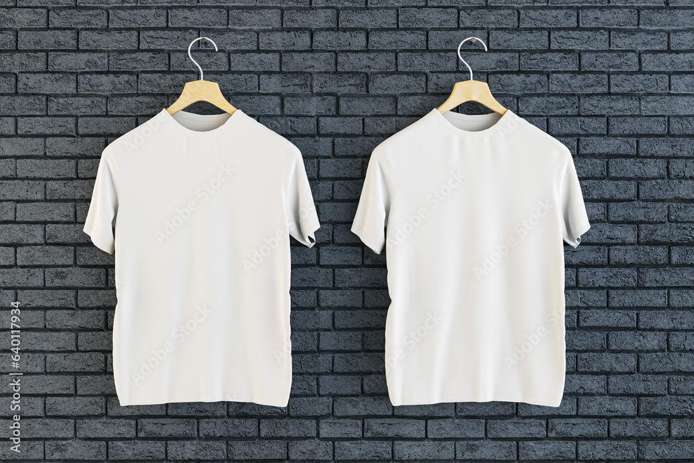 Two empty white t-shirts hanging on black brick wall background. Ad, textile and fashion concept. 3D