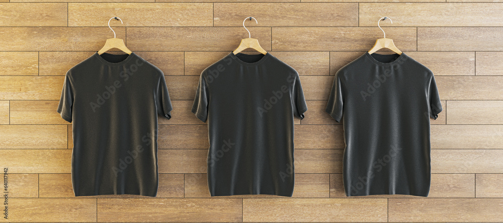 Three empty black t-shirts hanging on woooden wall background. Ad, textile and fashion concept. 3D R