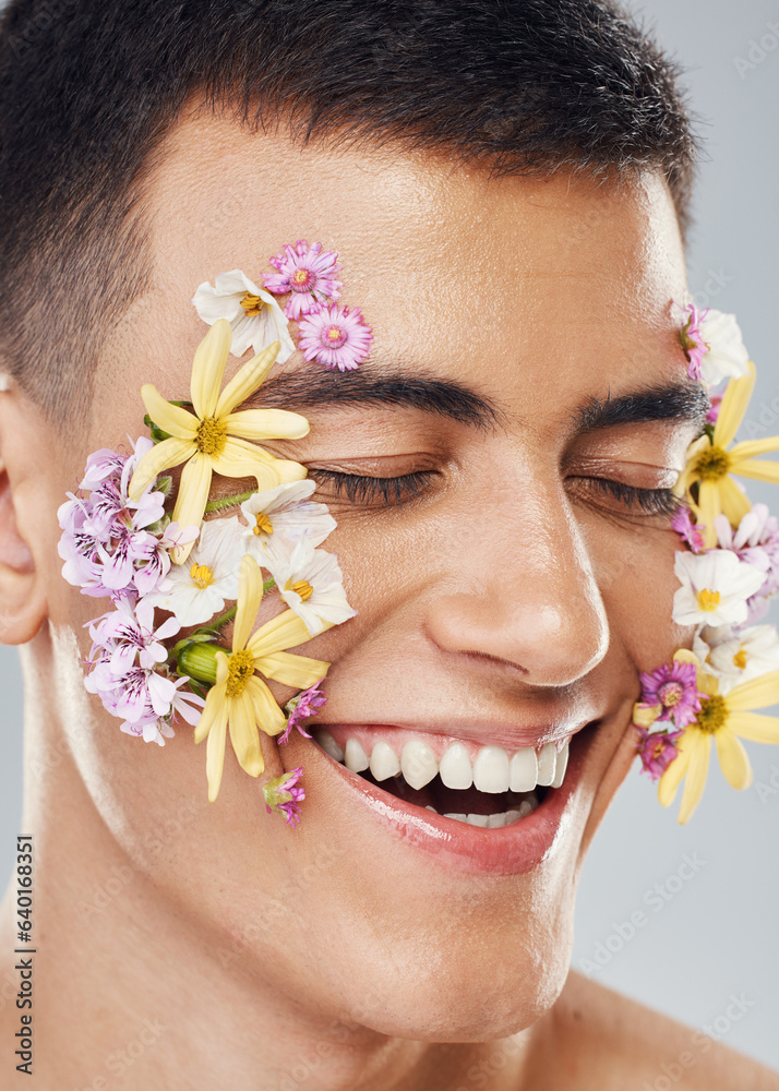 Smile, beauty and a man with flowers on a studio background for creative aesthetic. Happy, plant and