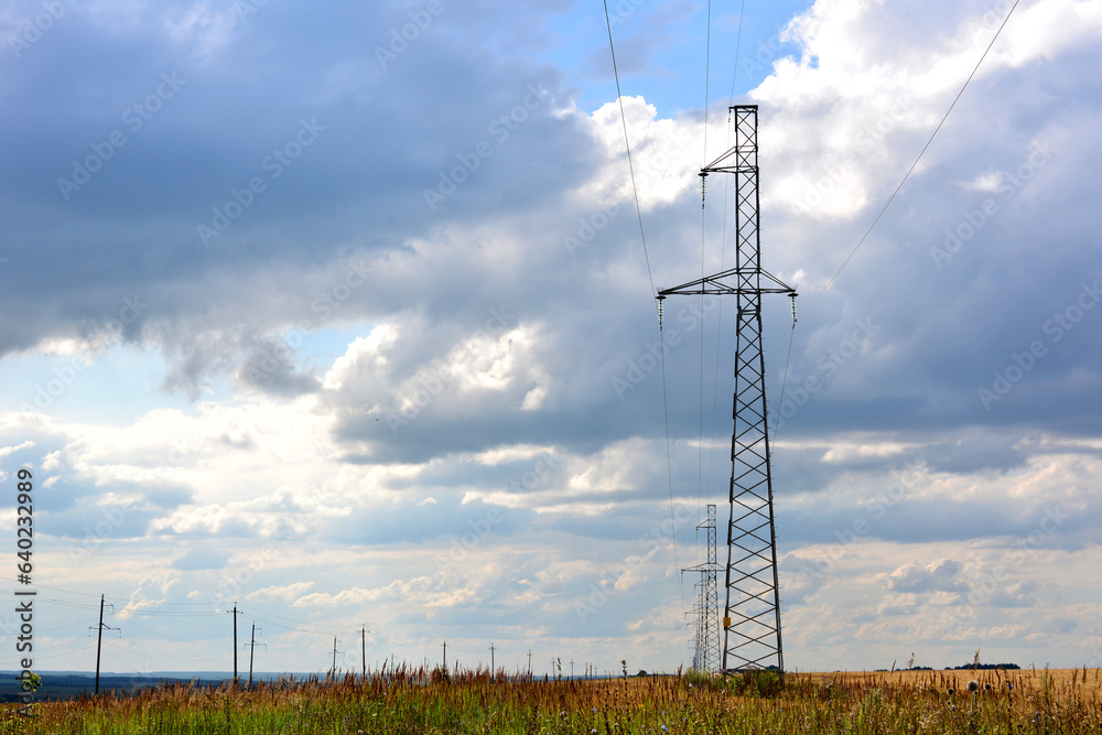 electric tower with wires on the field with cloudy sky on background copy space  