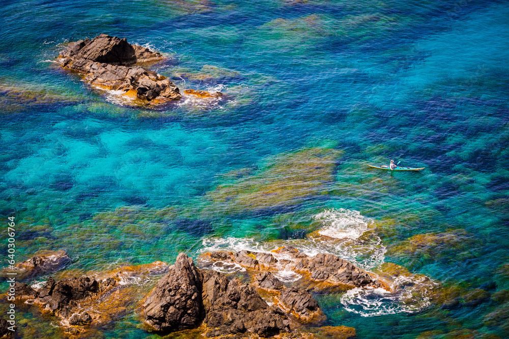 A man is sea kayaking at Pointe de la Parata, Ajaccio, Corse, France