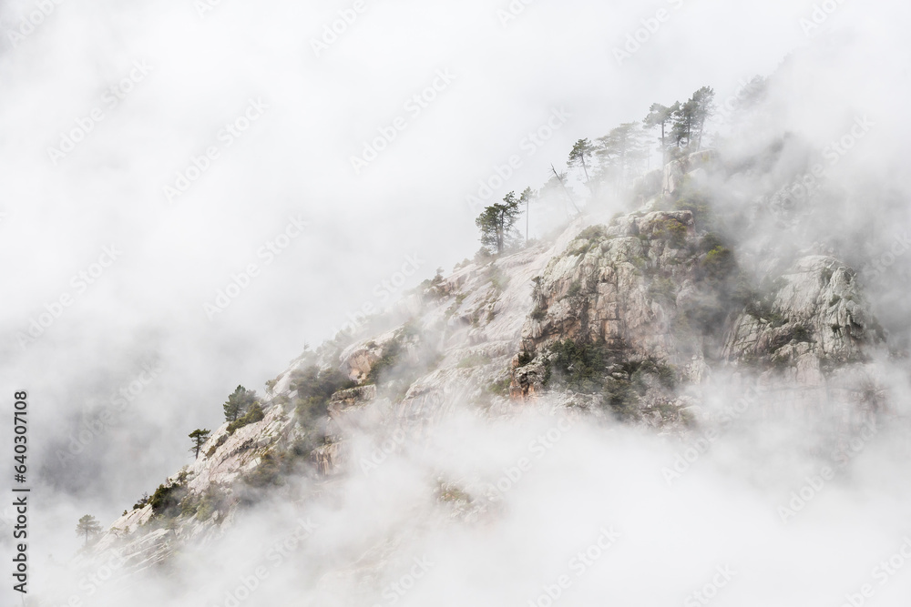 Rocky mountain slope in clouds in Corse, France