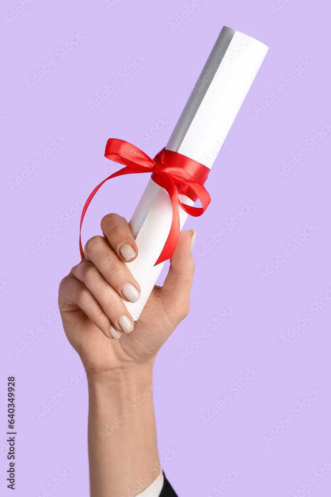 Woman holding diploma with ribbon on lilac background