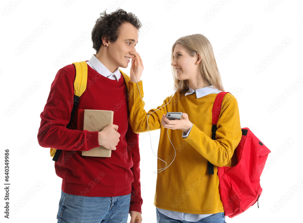 Teenage couple with earphones listening to music on white background