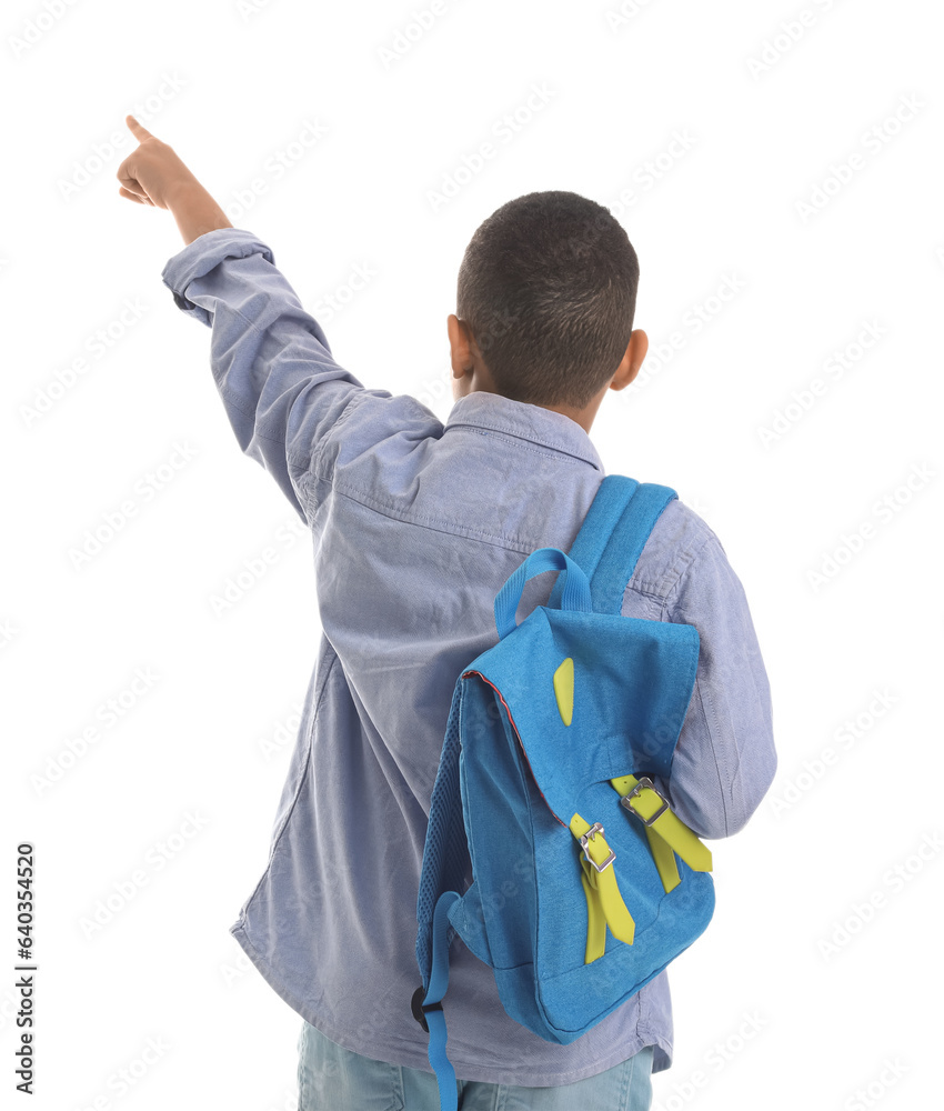 Little African-American schoolboy with backpack pointing at something on white background, back view