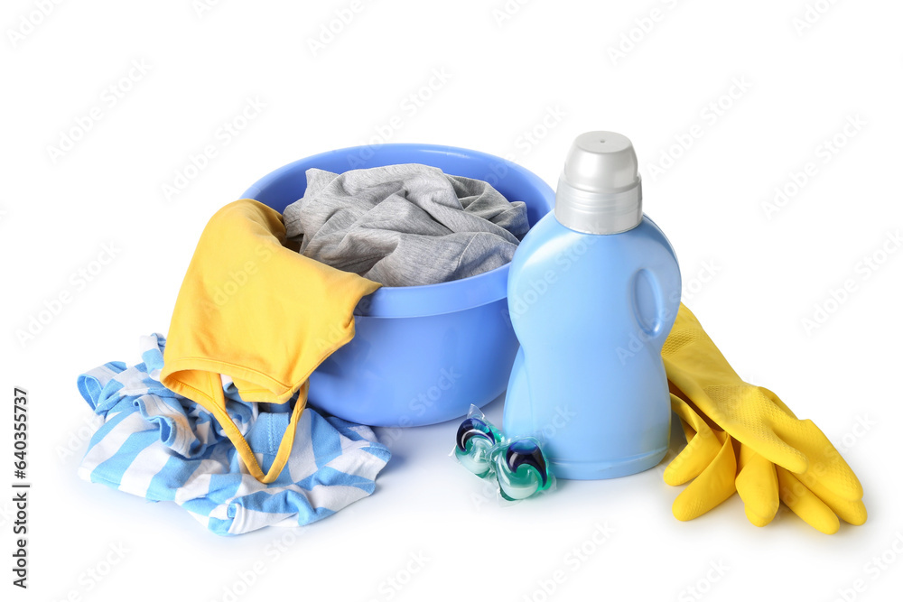 Plastic basin with dirty clothes, laundry detergent and rubber gloves isolated on white background