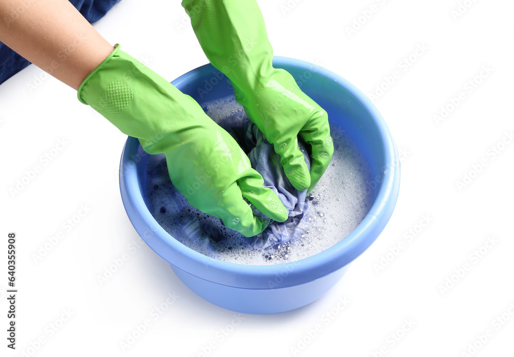 Woman in green rubber gloves washing clothes in plastic basin isolated on white background