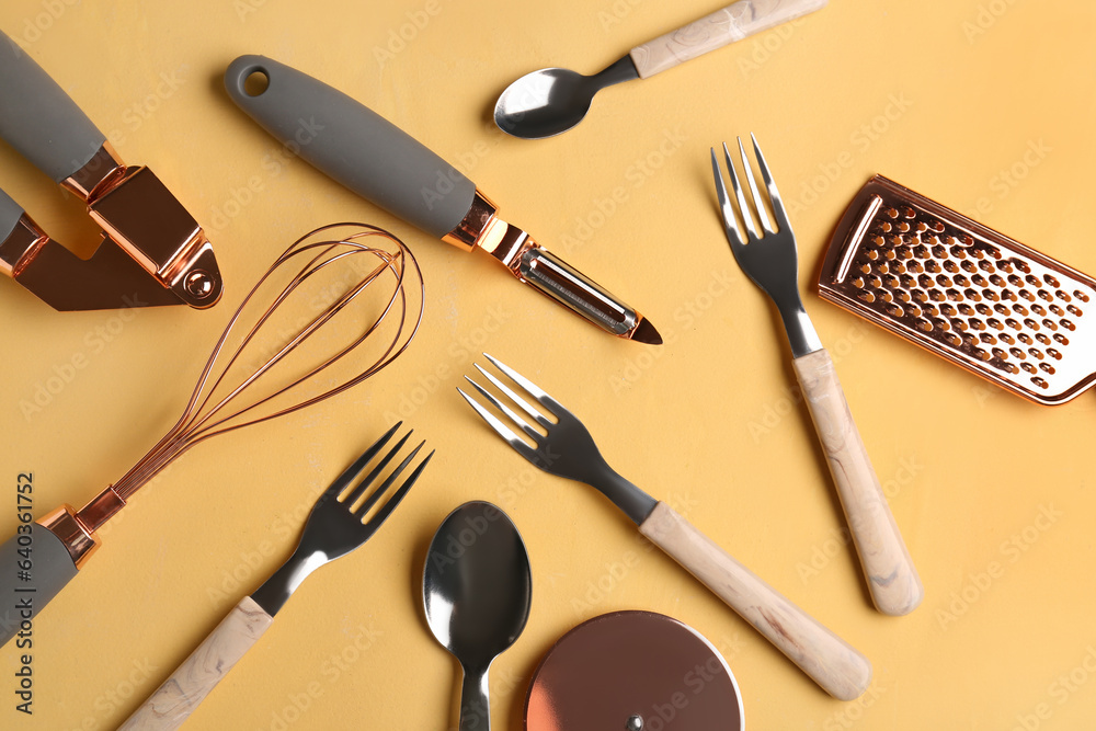 Different kitchen utensils on yellow background