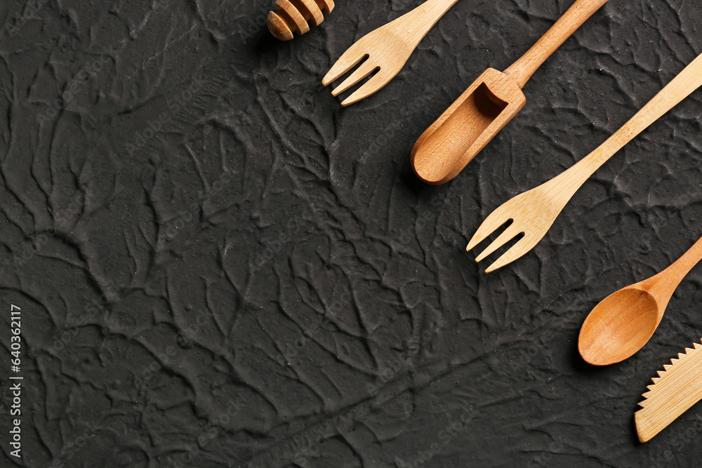 Different wooden kitchen utensils on black background