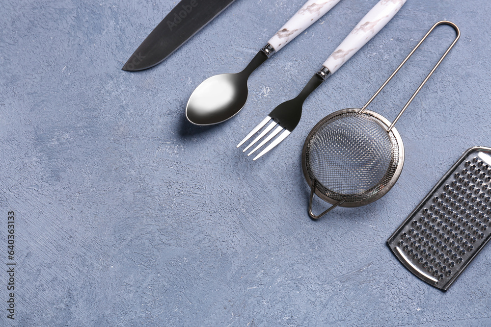 Different kitchen utensils on blue background