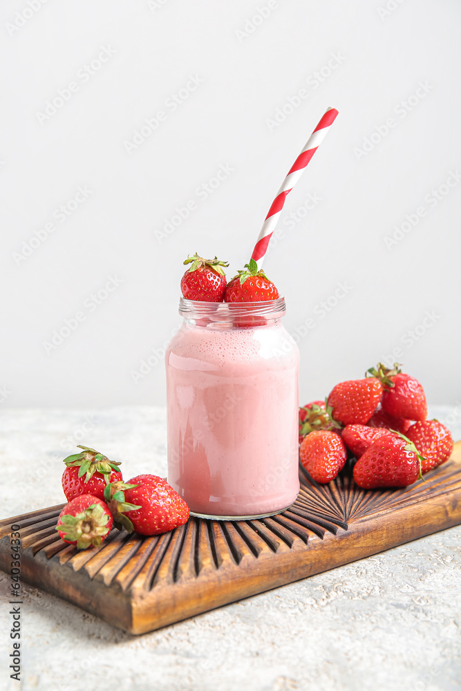 Mason jar of tasty strawberry smoothie on table