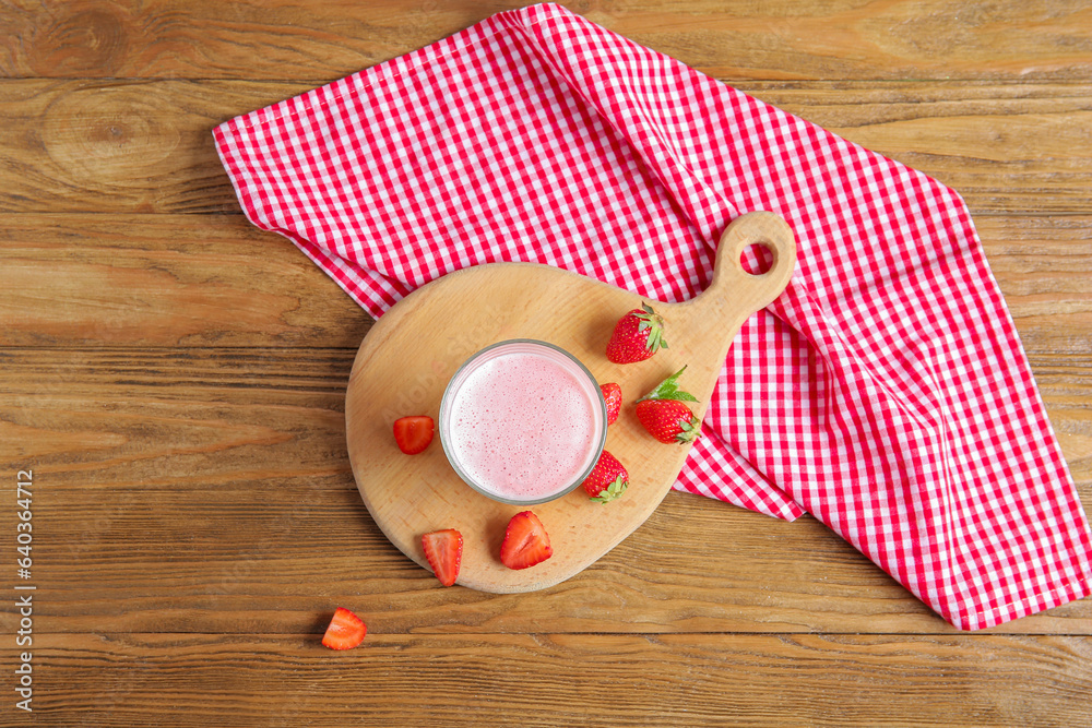 Glass of tasty strawberry smoothie on wooden background