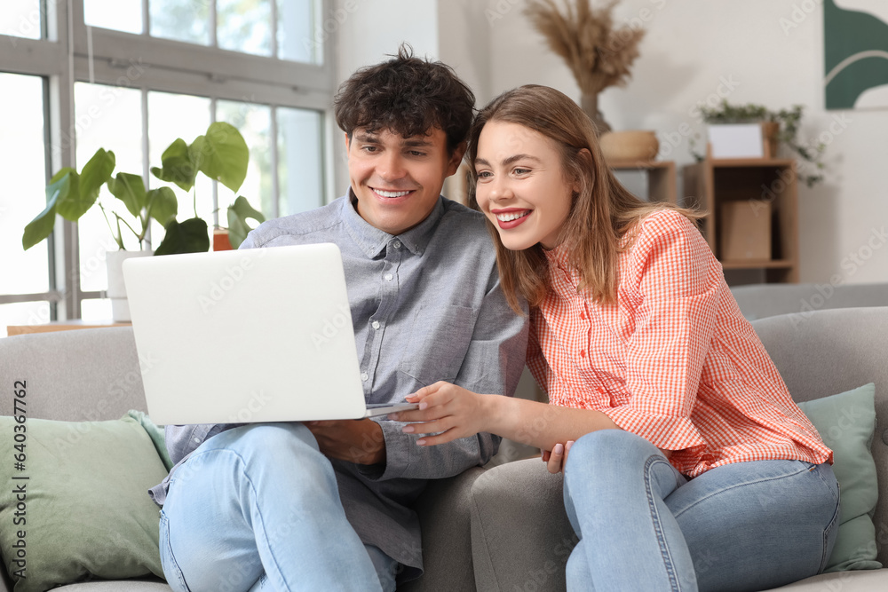 Young couple with laptop shopping online at home