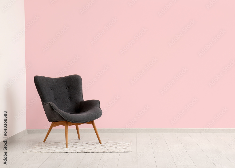 Grey armchair near pink wall