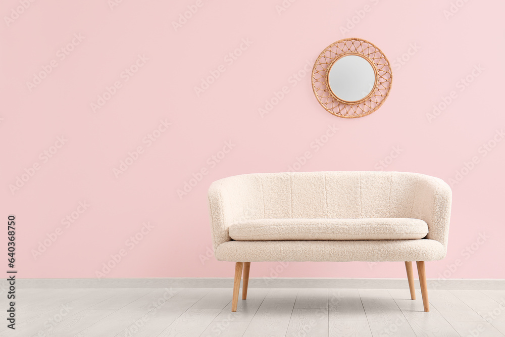 Cozy white sofa and mirror near pink wall