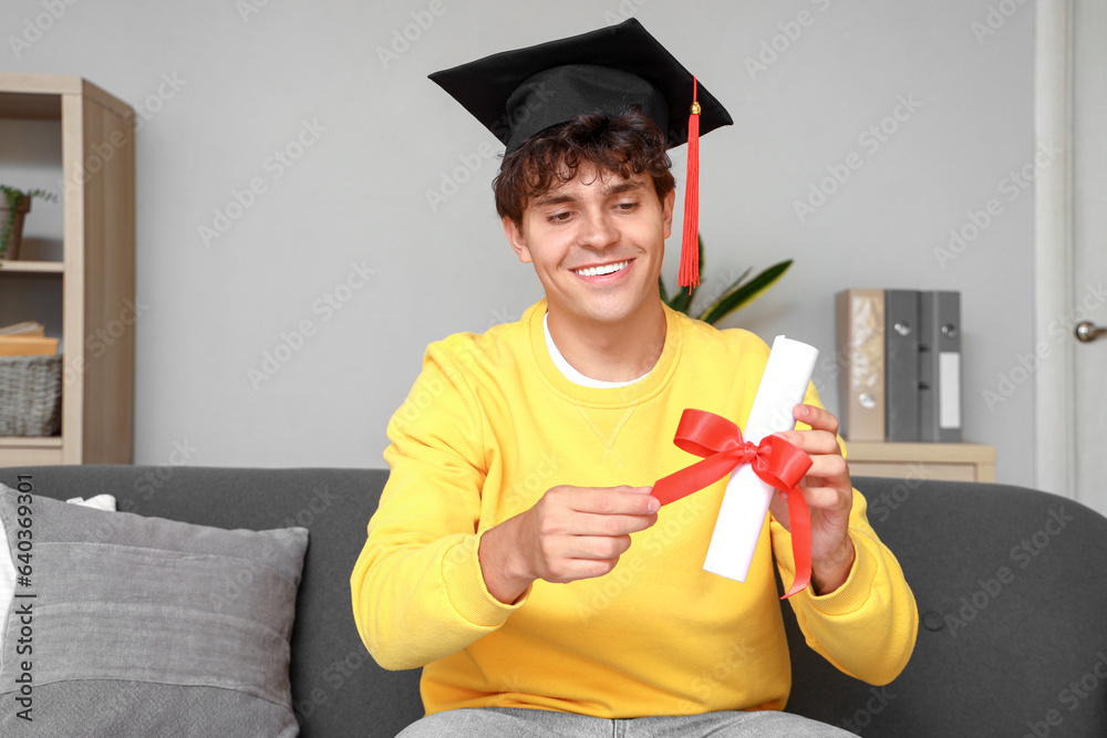 Male graduate student with diploma video chatting at home