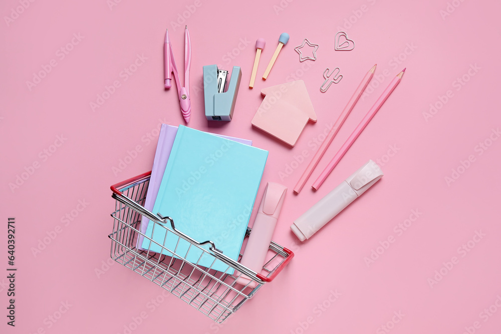 Composition with shopping basket and different stationery on pink background