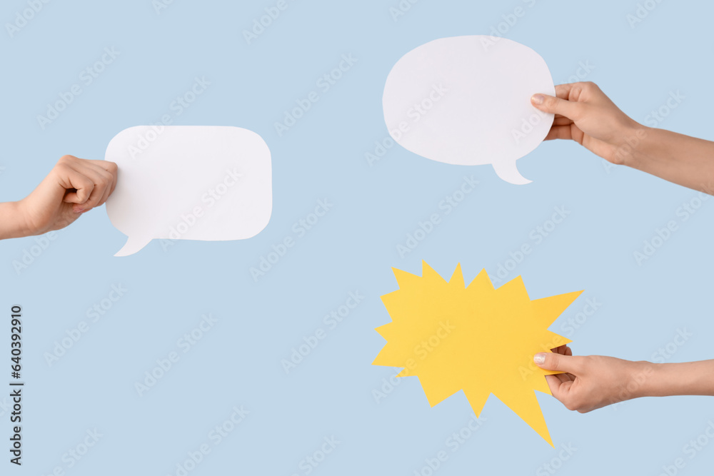 Female hands with speech bubbles on blue background