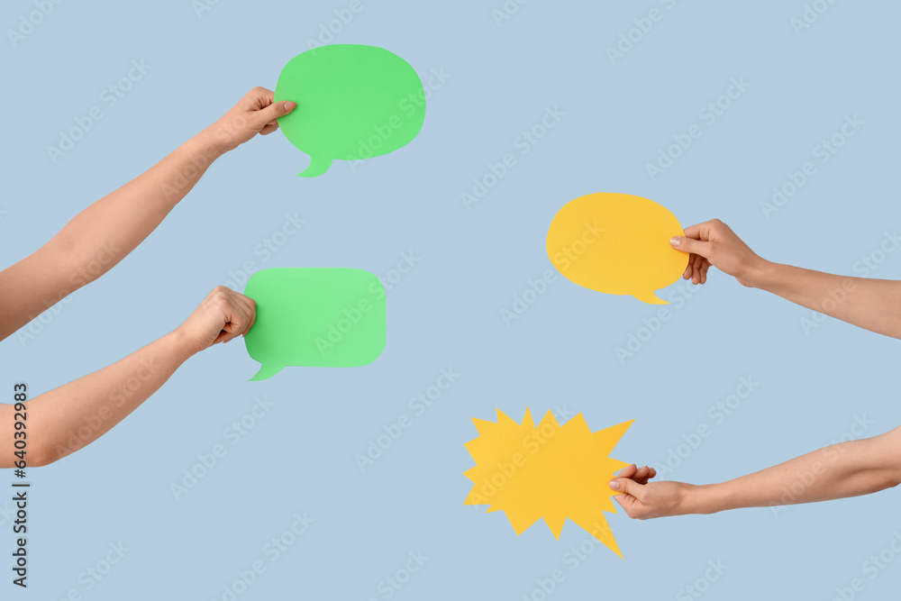 Female hands with speech bubbles on blue background