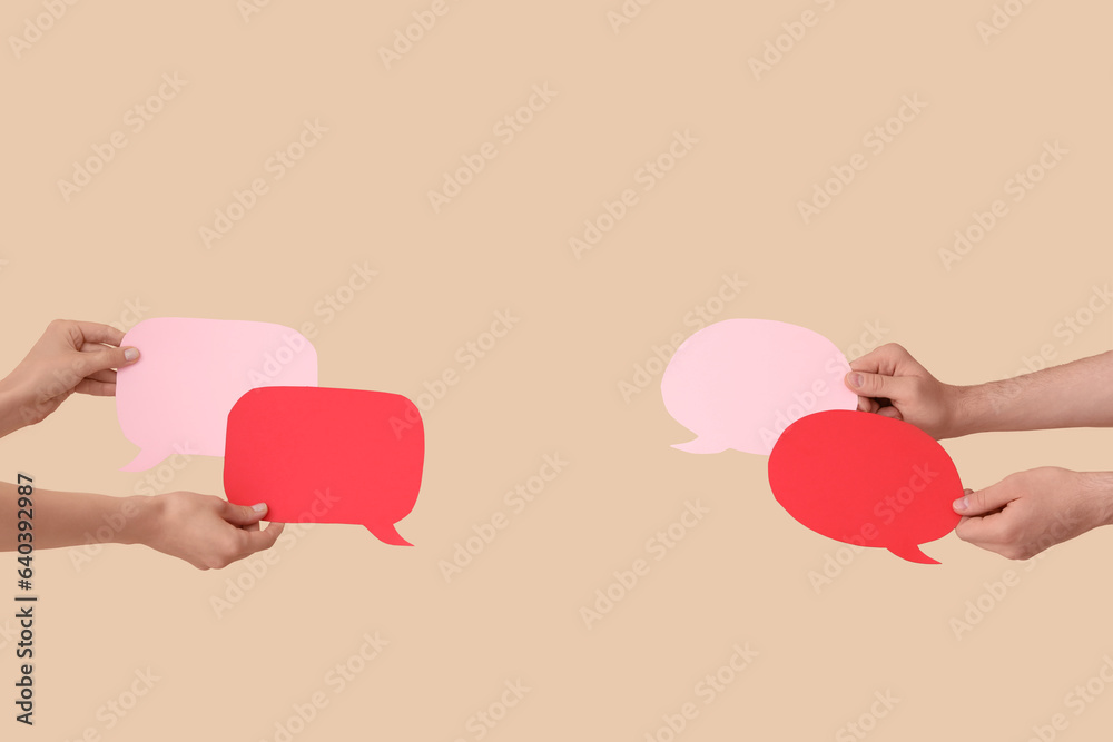 Different hands with speech bubbles on beige background