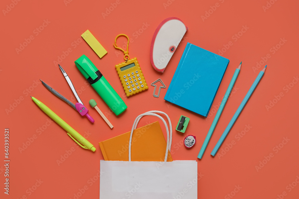 Shopping bag with different school stationery on orange background