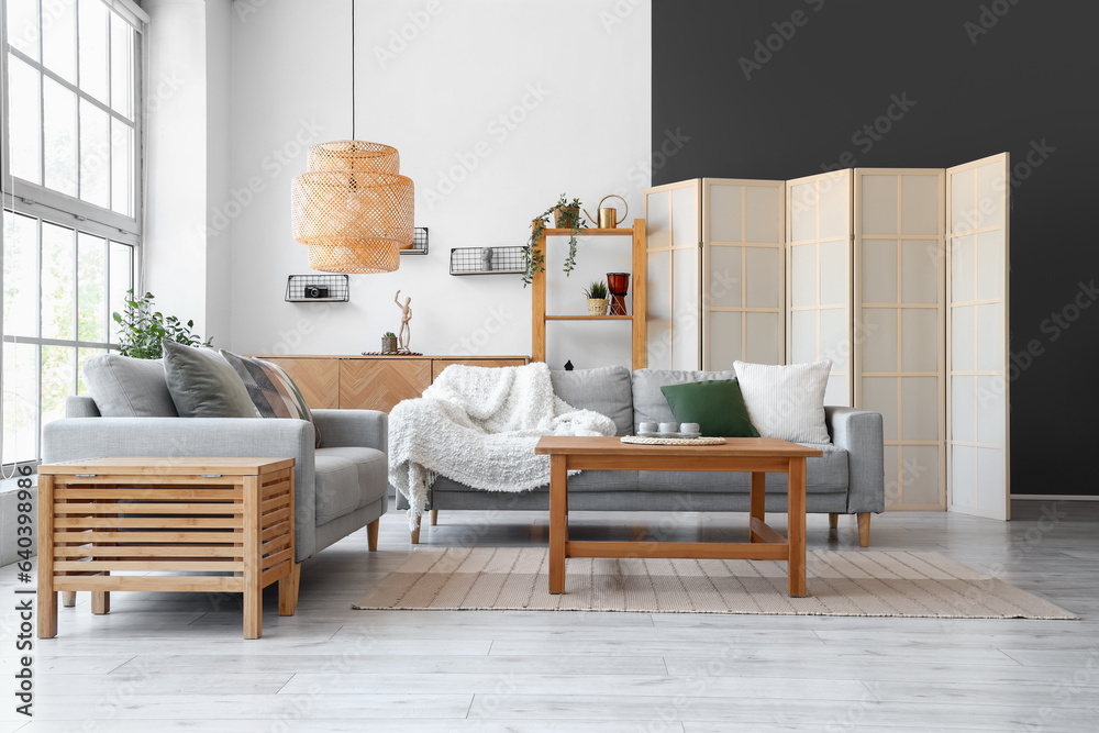 Interior of light living room with grey sofas and coffee table