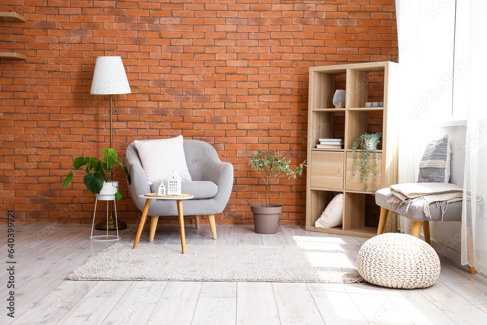 Stylish grey armchair and coffee table in interior of living room