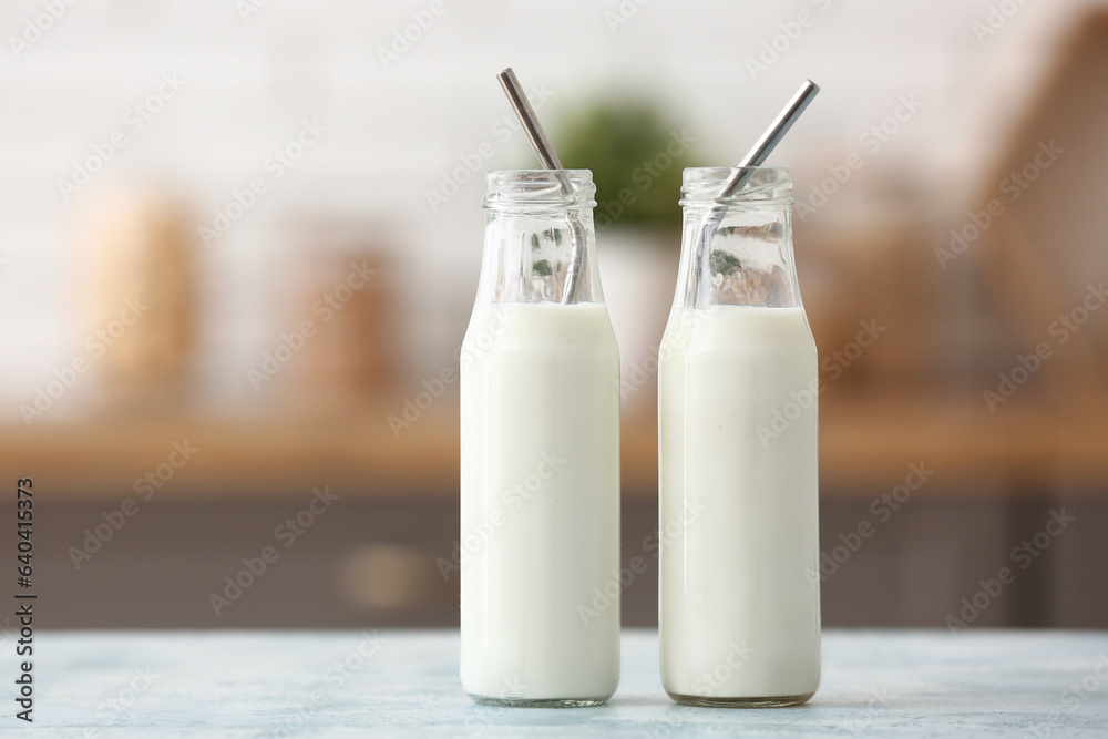 Bottles of fresh milk on blue table in kitchen