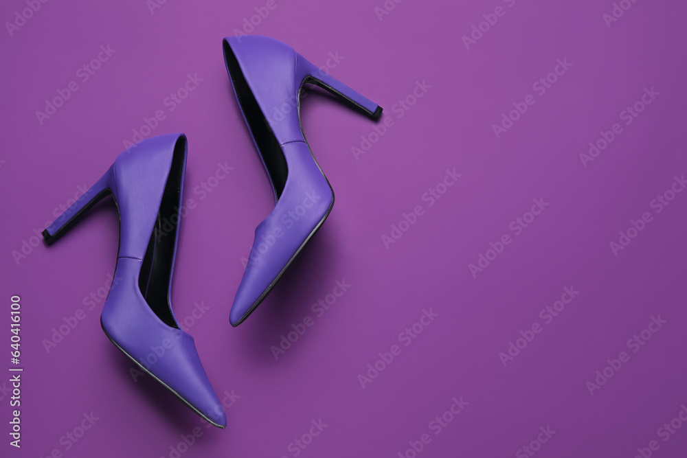 Stylish purple high heels on color background