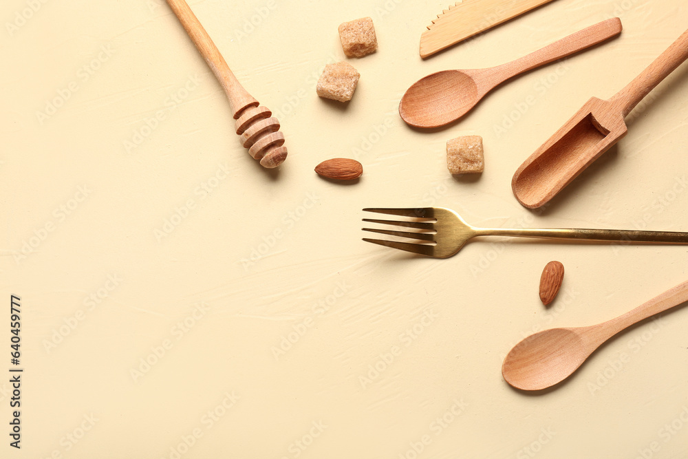 Different kitchen utensils, almond and sugar on yellow background