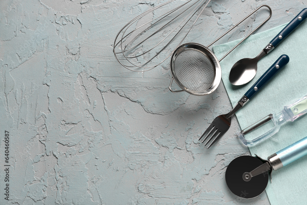 Different kitchen utensils on grey background