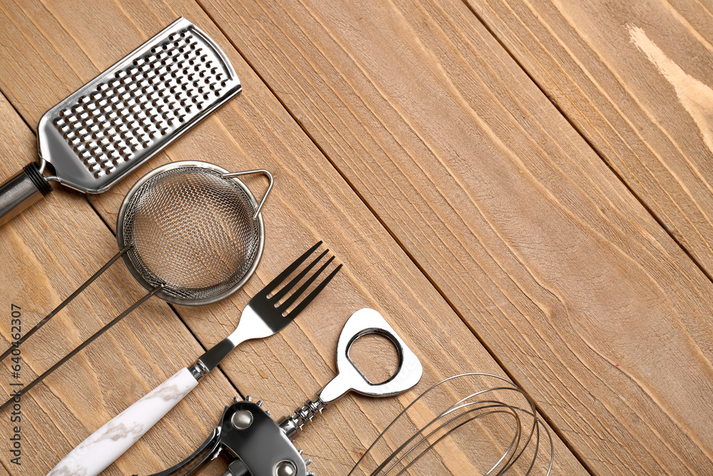 Different kitchen utensils on wooden background