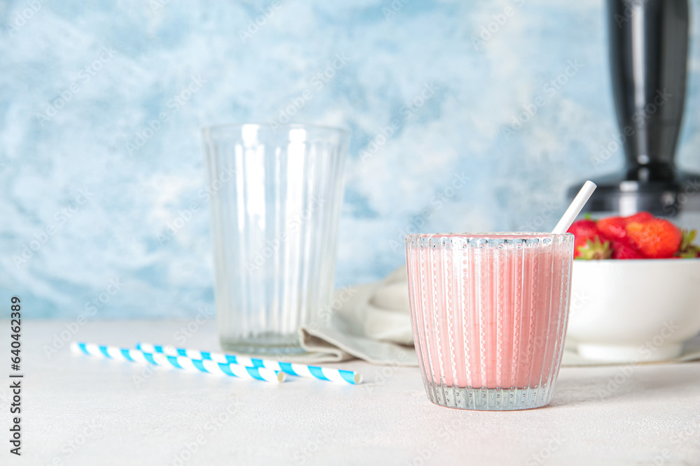 Glass of tasty strawberry smoothie on table