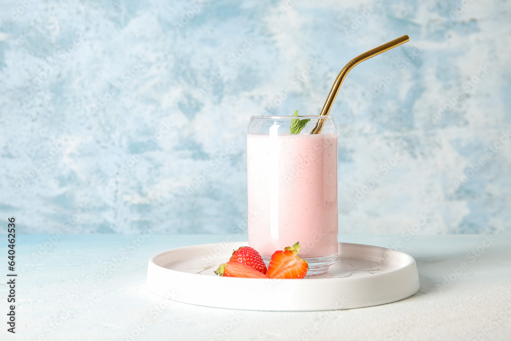 Glass of tasty strawberry smoothie on table