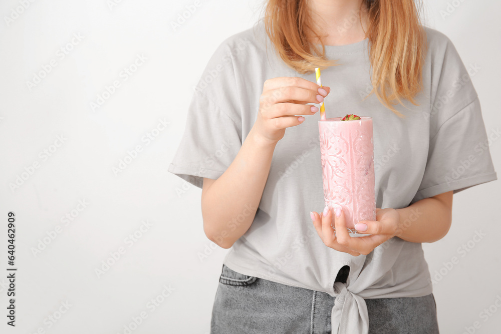 Woman holding glass of tasty strawberry smoothie on white background