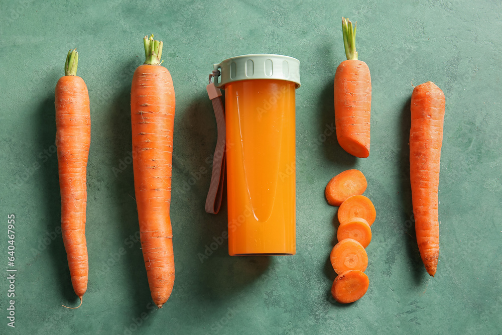 Sports bottle of fresh carrot juice on green background