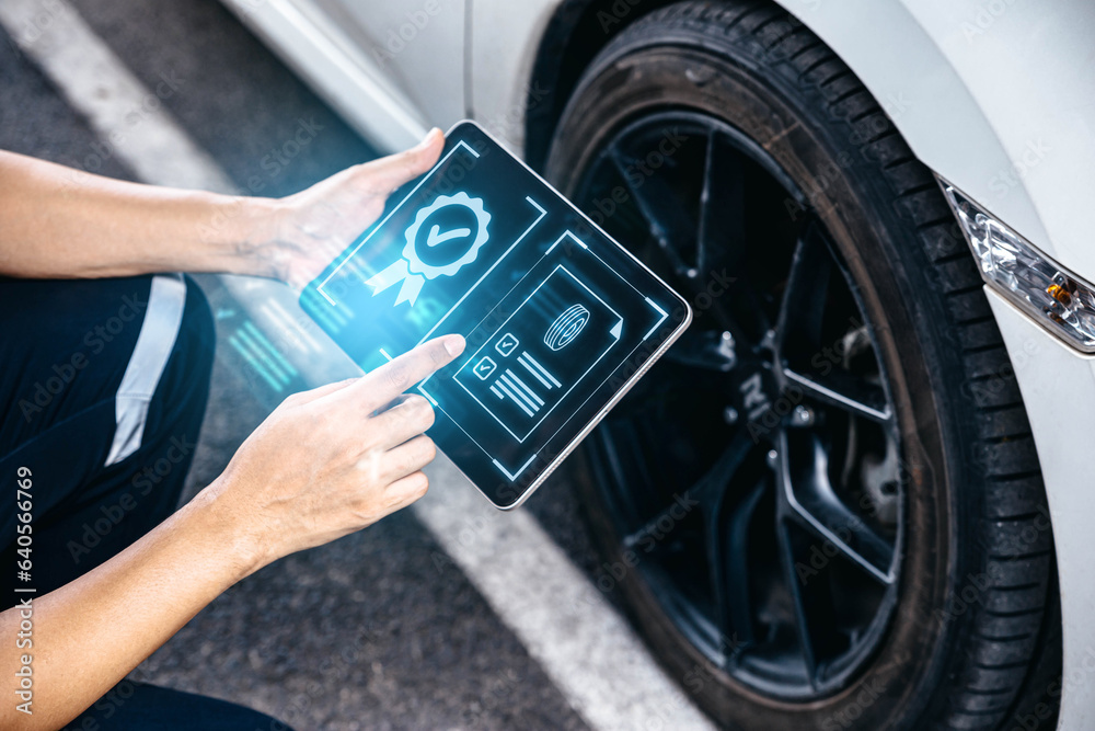 Mechanic technician holding tablet and checking to car tire in auto repair shop garage, Wheel tire r