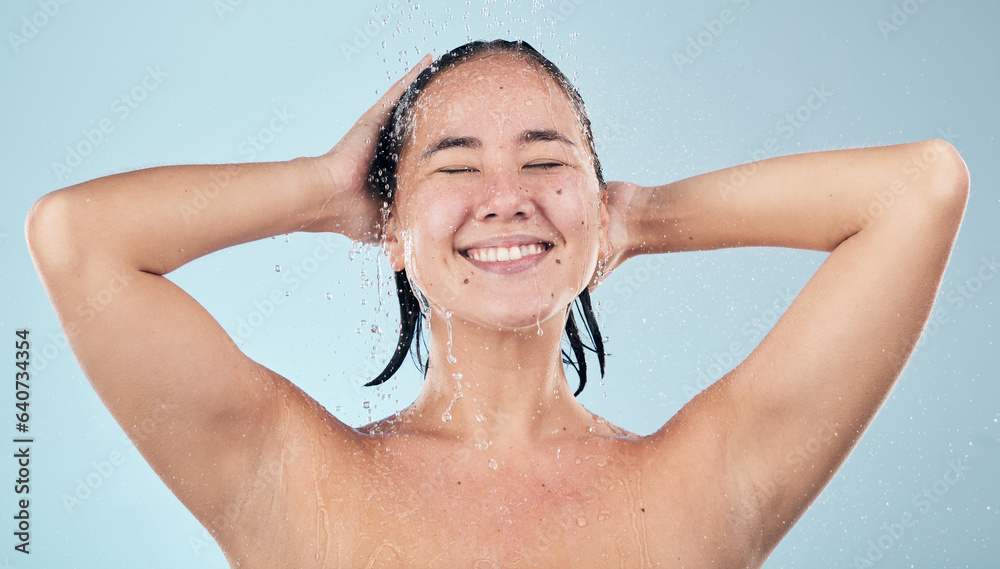 Shower, water or happy woman cleaning hair or body for wellness in studio on blue background. Smile,