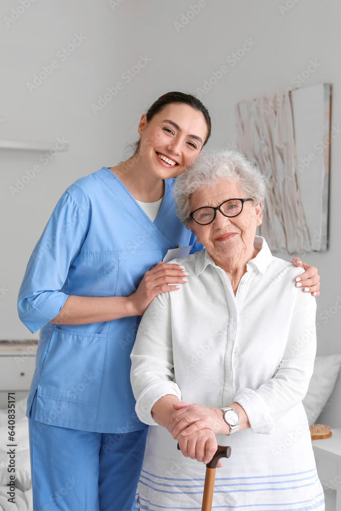 Young caregiver with senior woman in bedroom