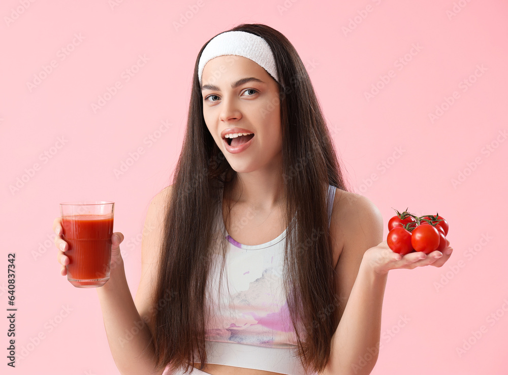 Sporty young woman with glass of vegetable juice and tomatoes  on pink background