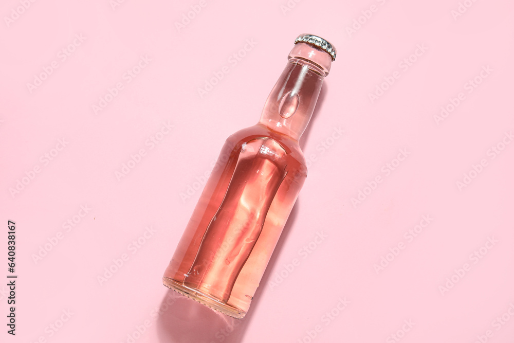 Bottle of fresh soda on pink background