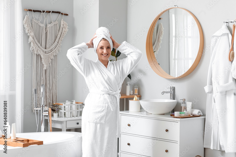 Mature woman with towel in bathroom