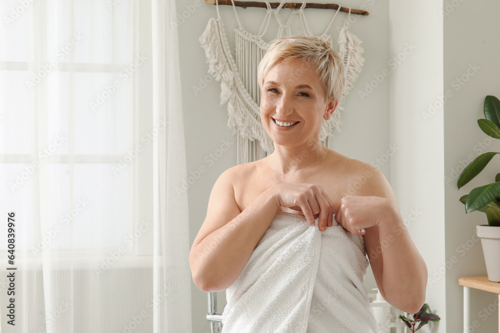 Mature woman with towel after shower in bathroom