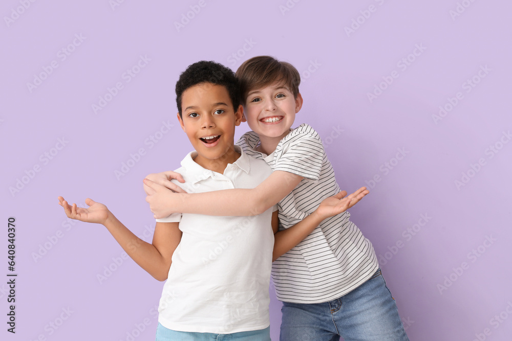 Cute little boys hugging on lilac background