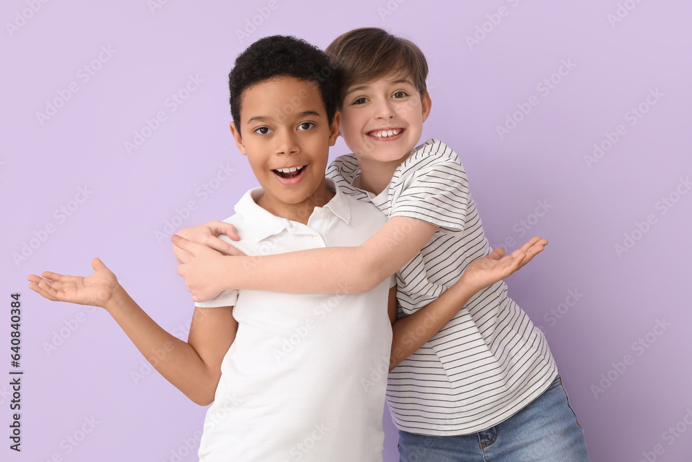 Cute little boys hugging on lilac background