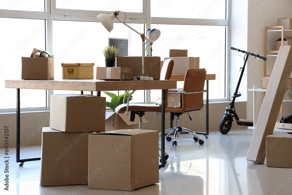 Interior of office with cardboard boxes on moving day