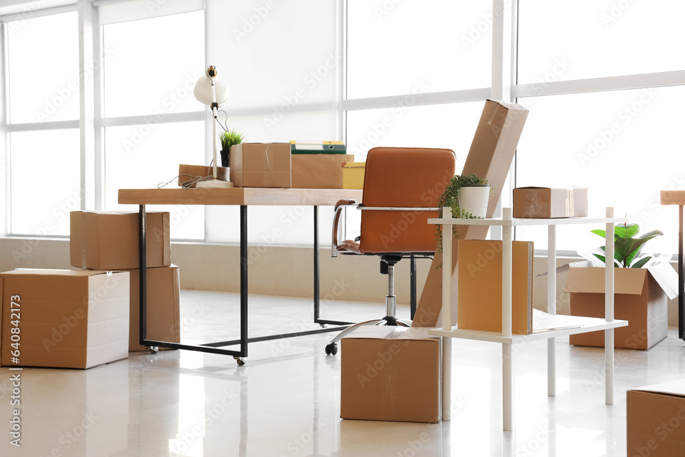 Interior of office with cardboard boxes on moving day